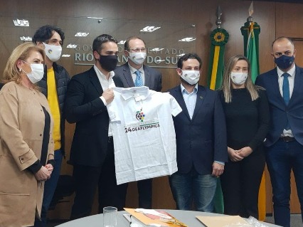 Seven people pose for photo while Mayor holding Caxias do Sul shirt